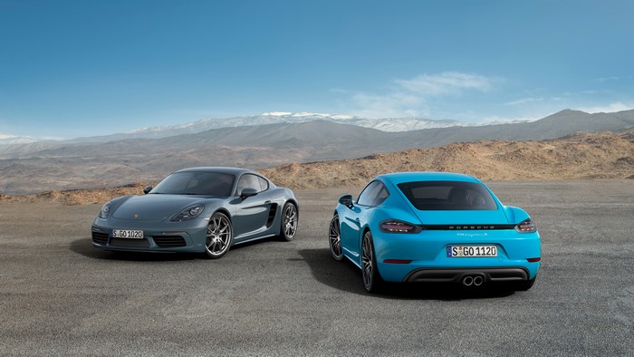 Two Porsche 718 Cayman cars in desert landscape