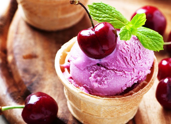 Cherry ice cream in a waffle cone with mint