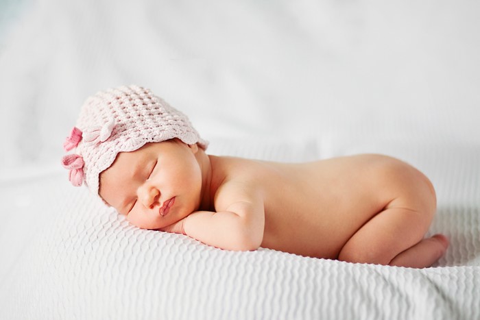 Newborn baby sleeping in a pink hat
