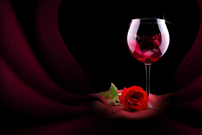 Glass of red wine and a red rose