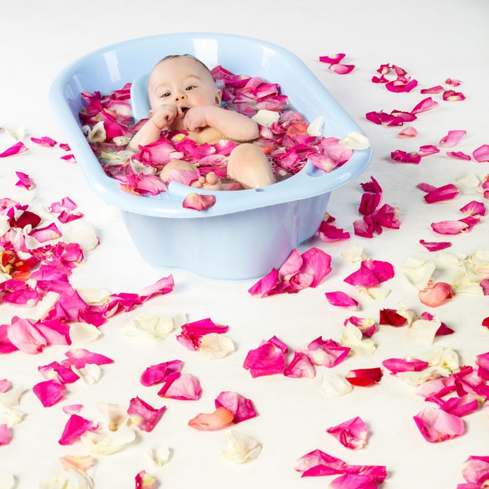 Baby in a bathtub with rose petals