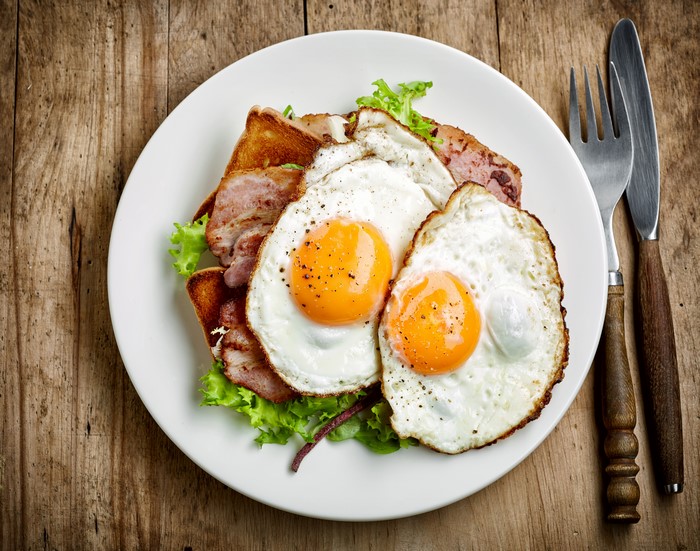 Fried eggs with bacon and toast on a plate