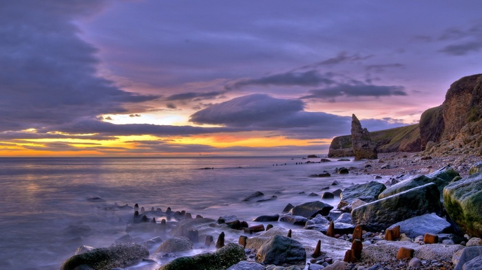 Rocky coastline at sunset with dramatic clouds
