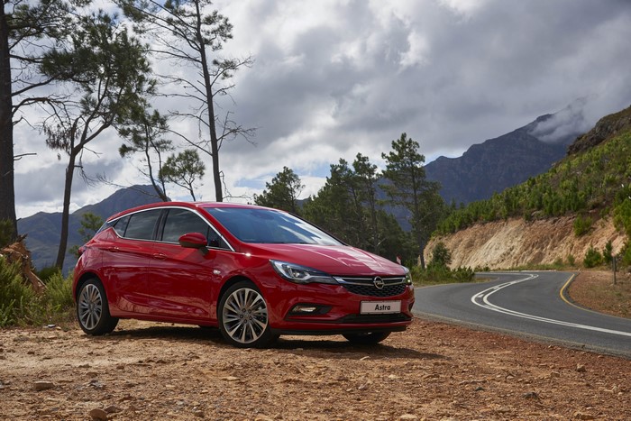 Red 2016 Opel Astra parked on a dirt road