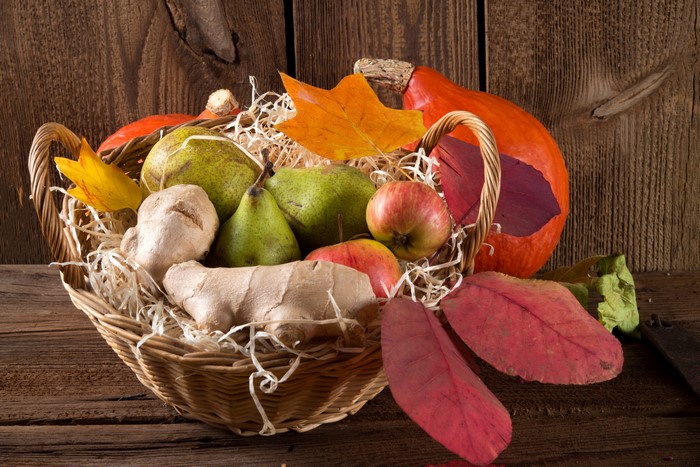 Wicker basket with pears, apples, ginger, and pumpkin