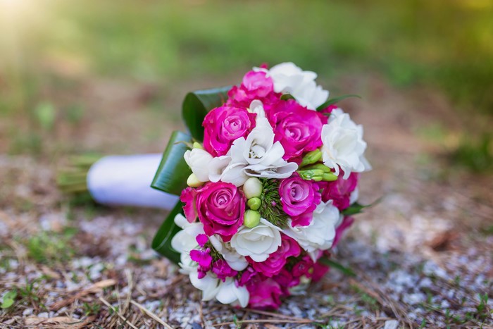 Pink and white roses and freesia bouquet on ground
