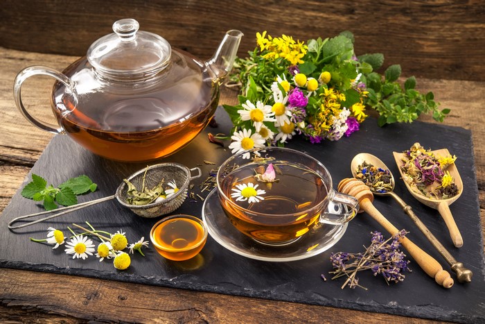 Still-life of tea with camomiles and herbs