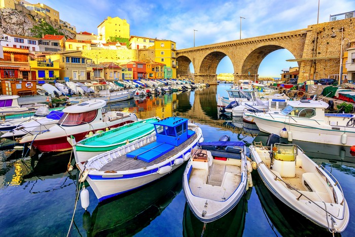 Boats in a harbor with a stone bridge in Marseille, France