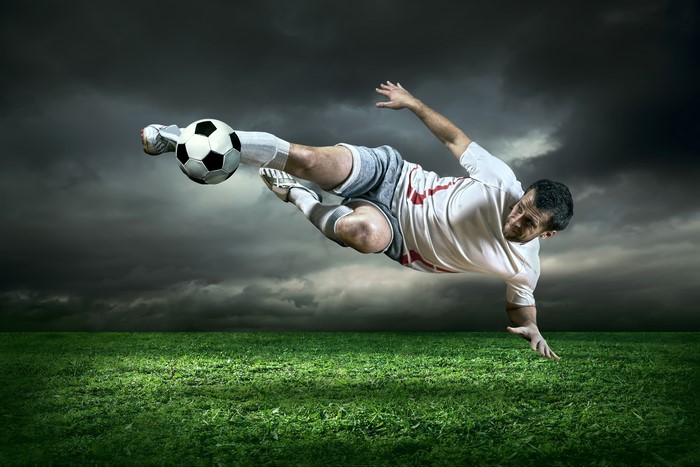 Man playing soccer on a grassy field