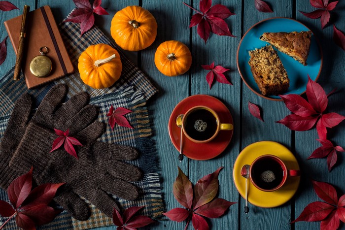 Still-life with coffee, pumpkins, pastry, and gloves