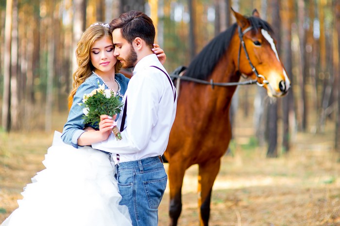Couple with horse and bouquet in forest