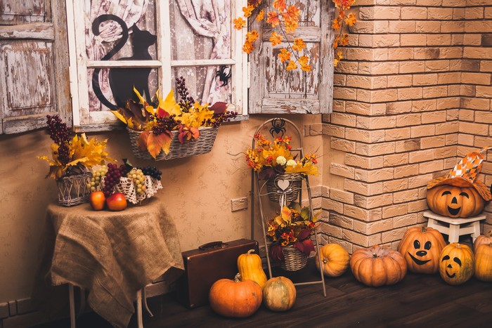 Halloween decorations with pumpkins, apples, and grapes