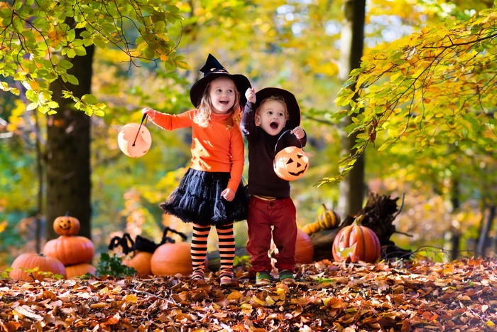 Children in Halloween costumes with pumpkins