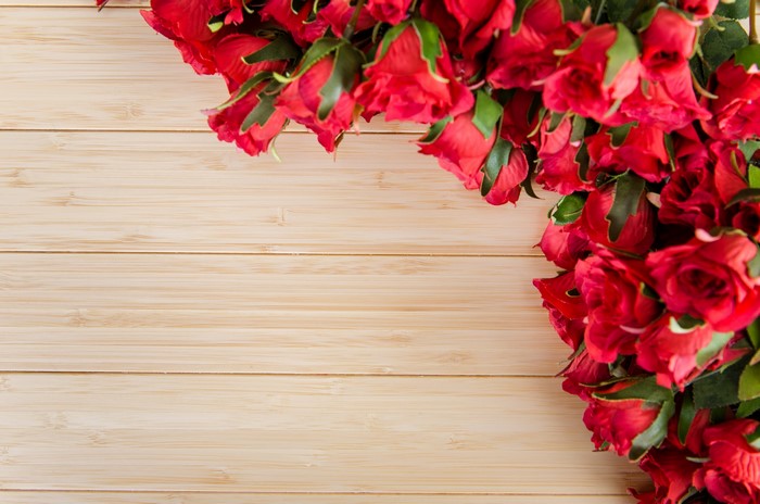 Red roses on a wooden background