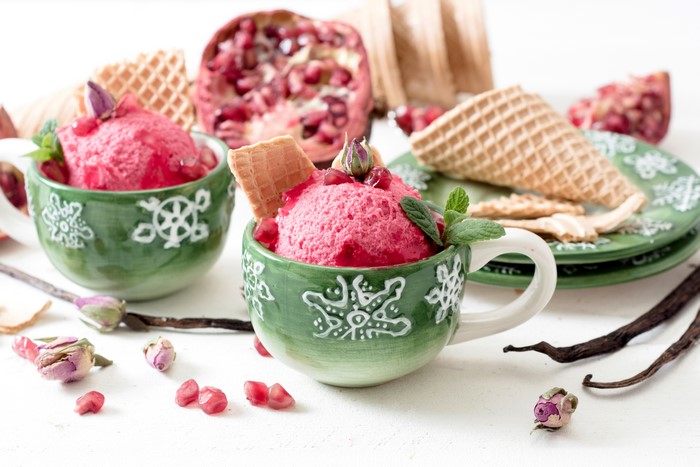 Pomegranate ice cream with waffle cones and garnishes