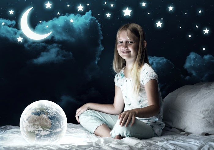 Girl on a bed with Earth and night sky