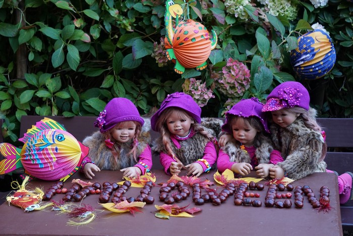 Dolls dressed for Halloween with chestnuts spelling out "Halloween"