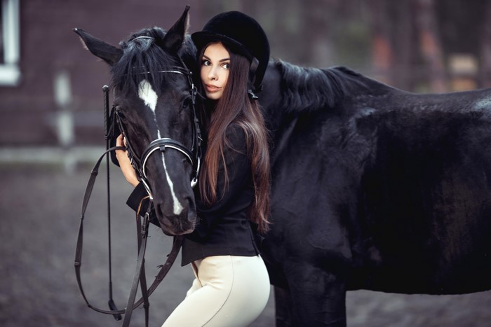 Woman in equestrian uniform with black horse