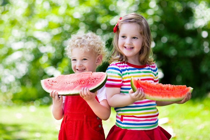Two children eating watermelon slices