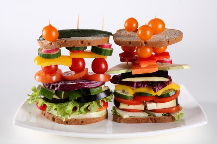 Two vegetable sandwiches on a white plate
