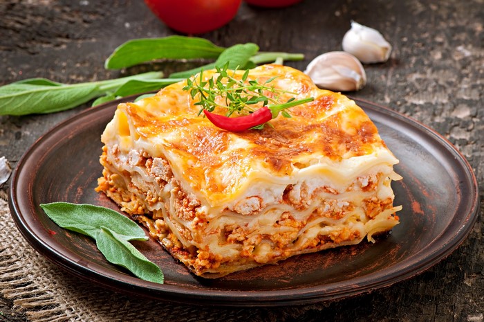 Lasagne on a plate with chili and herbs