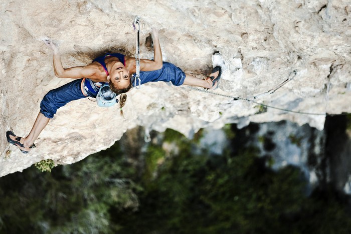 Woman rock climbing on a cliff face
