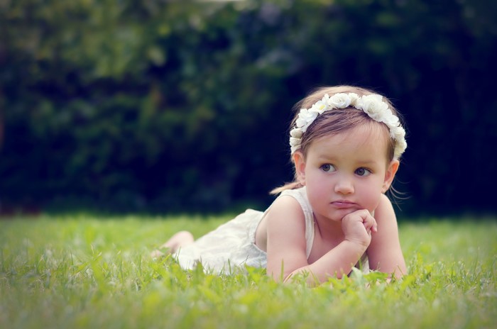 Little girl with flower crown on grass