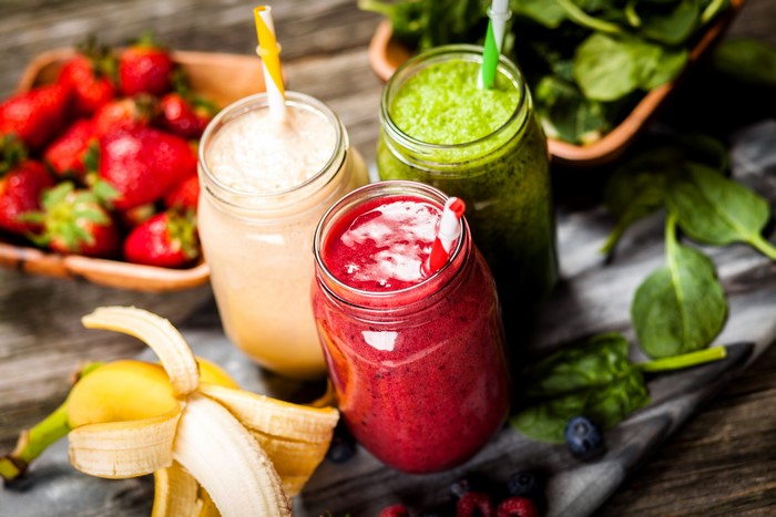 Three colorful smoothies with fruits and spinach