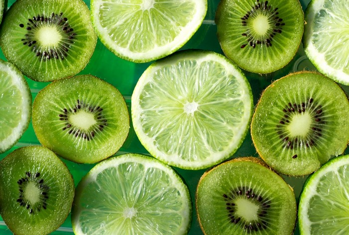 Slices of kiwi and lime on a green background