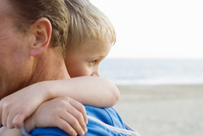 Father holding his son on the beach
