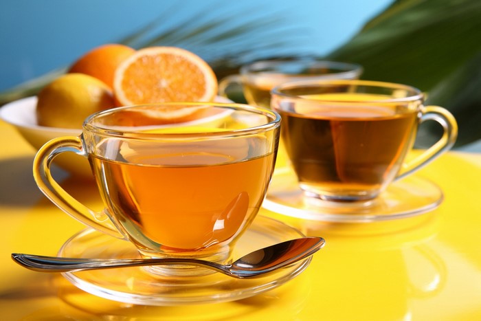 Two cups of tea with oranges and lemons