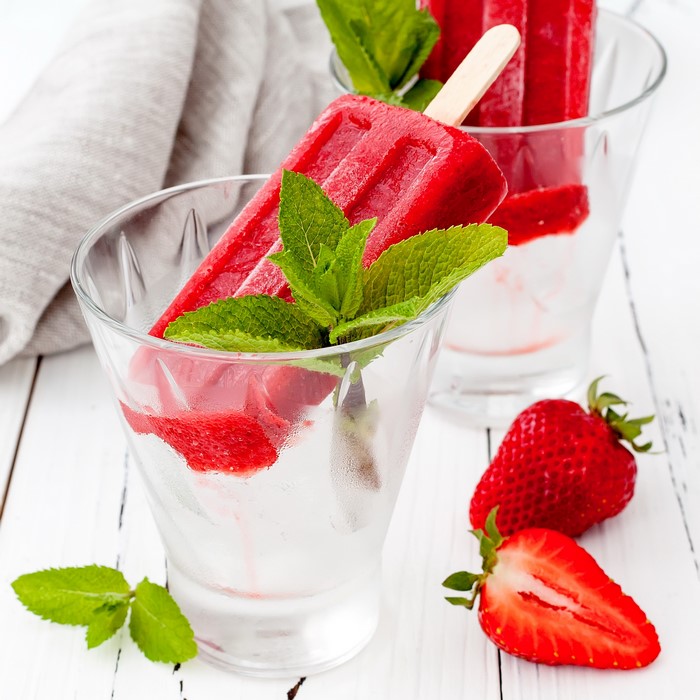 Strawberry popsicles with mint in glasses