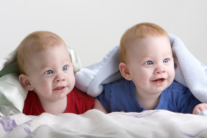 Two babies under a blanket