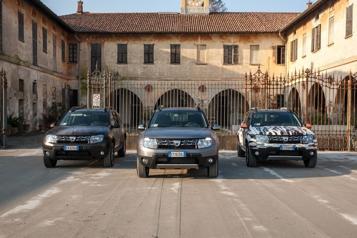Three Dacia Duster cars in front of a building