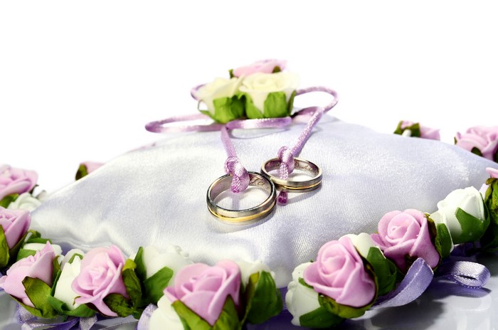 Wedding rings on a pillow with roses