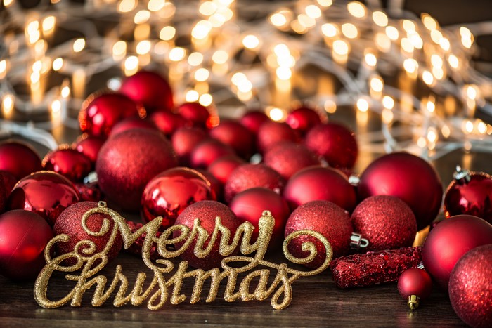Merry Christmas text with red ornaments and bokeh lights