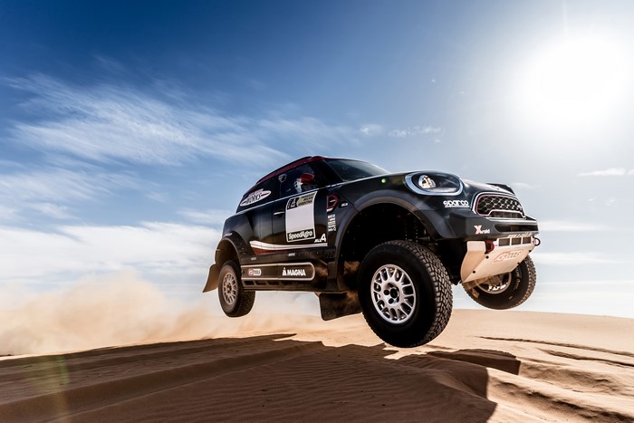 Mini John Cooper Works Rally car jumping over sand dunes