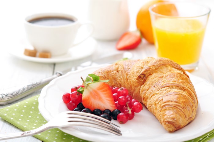 Croissant with berries, coffee, and orange juice