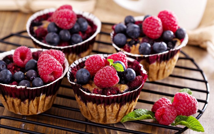 Berry muffins with raspberries and blueberries on a cooling rack