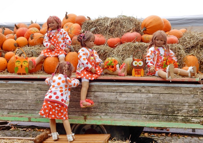 Dolls in pumpkin patch with hay bales