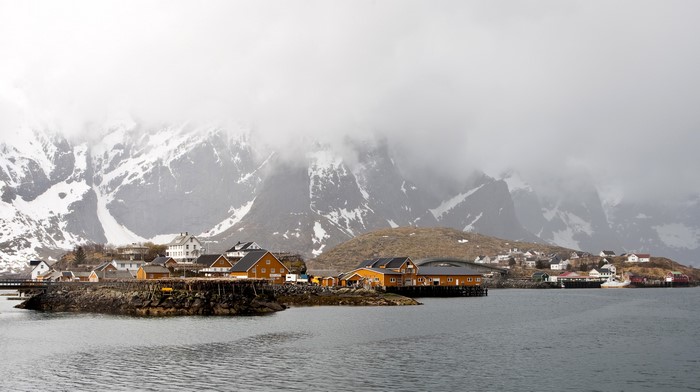Norwegian village with snow-capped mountains and a lake