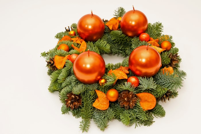 Advent wreath with orange candles and pine cones