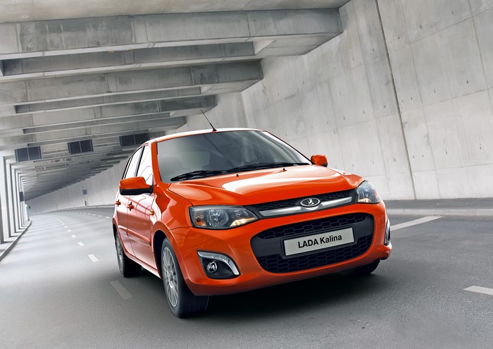 Orange Lada Kalina driving through a concrete tunnel