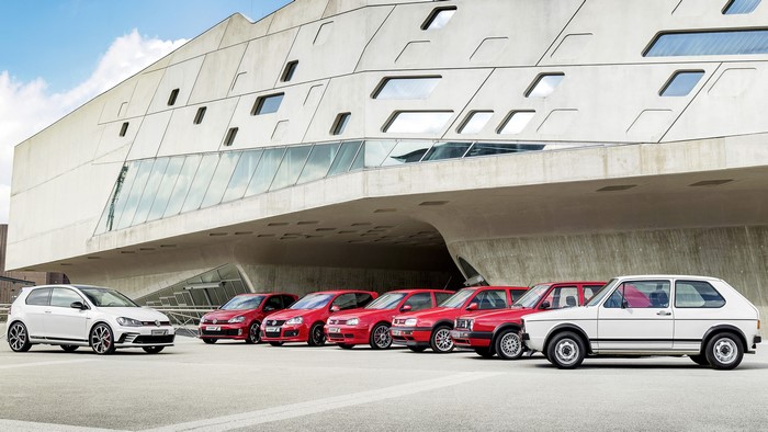 Volkswagen Golf Generations Lined Up Outside Modern Building