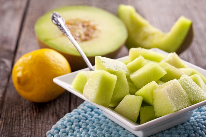 Cantaloupe pieces on a plate with lemon and melon