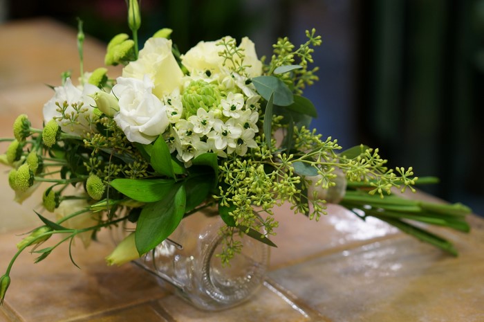 White and green floral bouquet in a glass vase