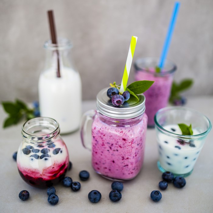 Blueberry smoothies and yogurt in jars and glasses