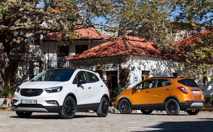 Two Opel Mokka X cars parked outside buildings