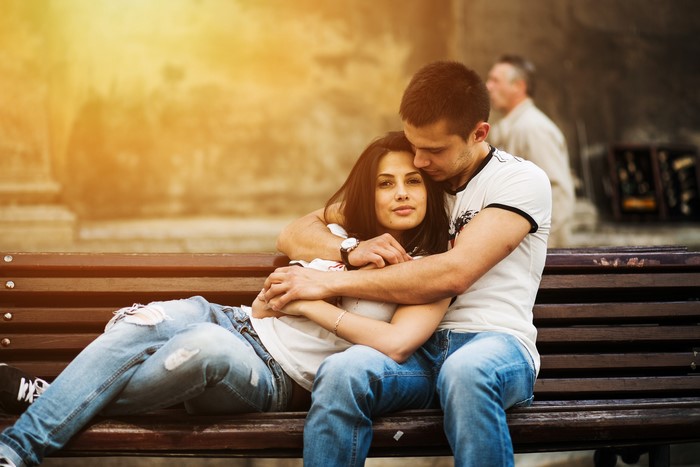 Couple hugging on a park bench