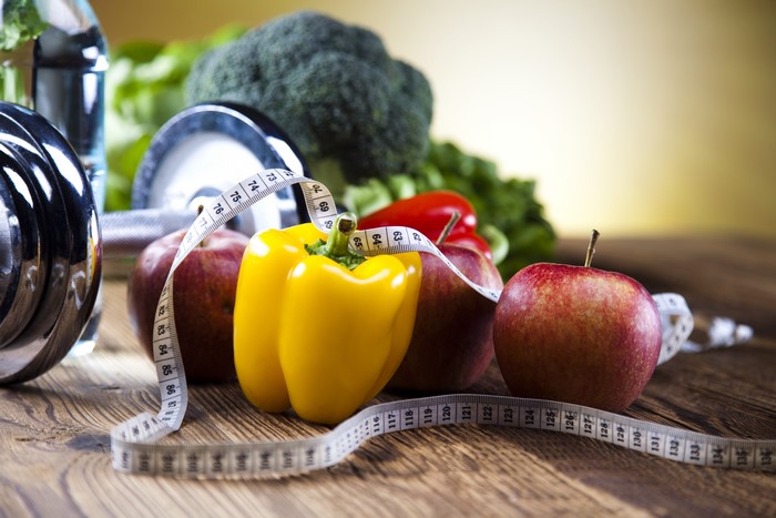 Bell pepper, apples, dumbbells, and tape measure